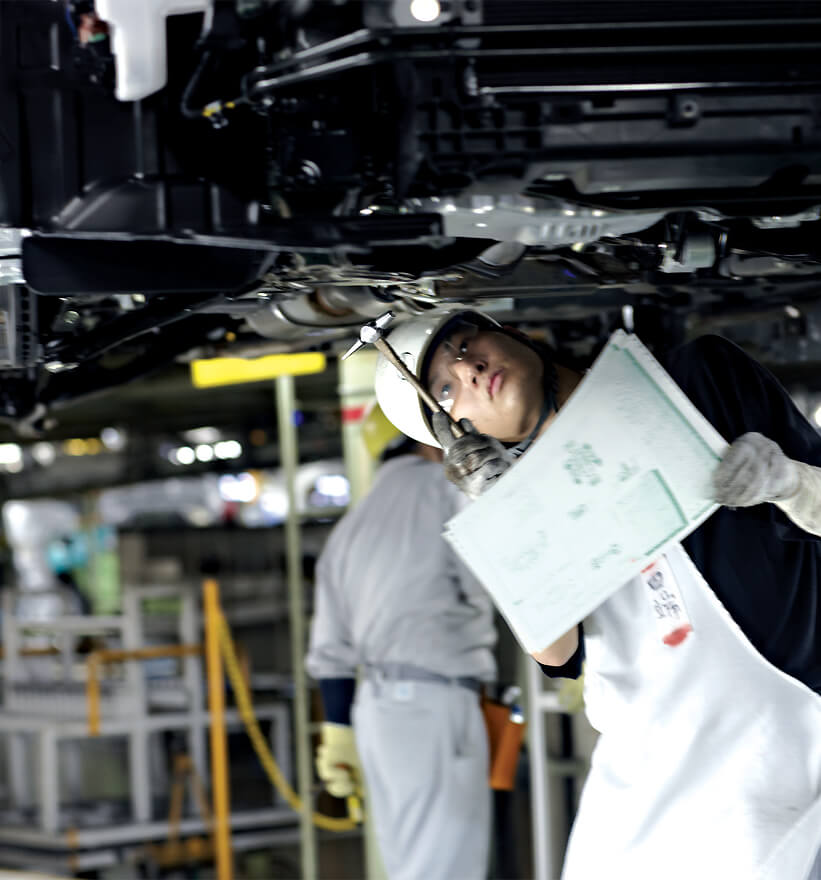 Mazda worker inspecting a car